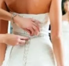 A perfect fit requires precise measurements. Here, I am taking detailed measurements for a wedding gown to ensure the back and waist fit the bride's body exactly, providing both comfort and a beautiful silhouette.