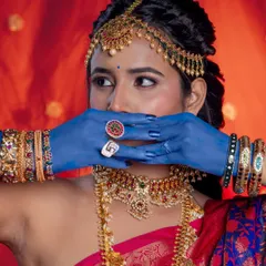 A creative pose that draws attention to both the intricate hairstyle and the bold, artistic elements of the shoot.