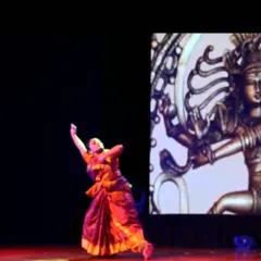 A powerful moment from a classical Bharatanatyam performance, set against a backdrop of Lord Shiva as Nataraja. We believe in expressing stories and emotions through every movement.