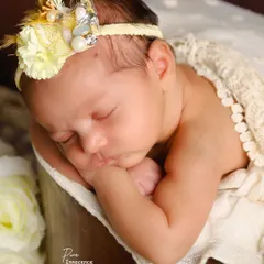 A close-up portrait highlighting the delicate features of a newborn. I use soft, natural lighting to gently illuminate your baby's face while they rest.