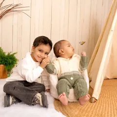 A sweet moment between two brothers in a cozy, boho-themed studio setup. Capturing sibling interactions is a key part of my family photography service.