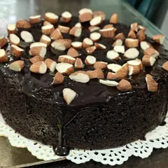 This rich chocolate cake, topped with crunchy almonds, strikes the perfect balance between health and indulgence. It's made without sugar, maida, or butter.