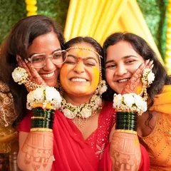 A beautiful moment of joy as the bride is surrounded by her friends and family during the Haldi ceremony.