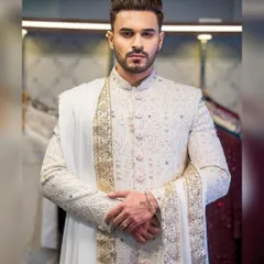 Actor Ayush Khatri looks regal in this fully embroidered white sherwani. The detailed threadwork and matching stole showcase a commitment to luxurious, high-end wedding attire.
