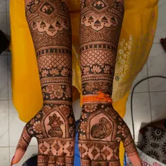 A complete view of a traditional bridal mehendi design. The symmetrical patterns extend up to the elbows, featuring classic motifs like kalash pots, elephants, and lotuses for a grand and timeless look.