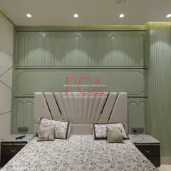 The master bedroom in The Cursive Abode, with a custom bed set against a sage green wall with neoclassical-inspired paneling. The design creates a tranquil and elegant retreat.