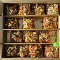 A close-up of my homemade Baklava pieces. You can see the generous sprinkle of chopped pistachios on top of the golden, flaky layers of phyllo pastry.