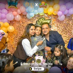 A beautiful family portrait during a birthday celebration. The parents and birthday girl pose for a photo in front of the sparkling sequin backdrop.