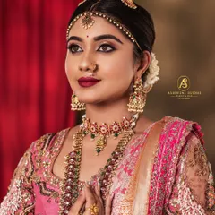 This is my signature muhurtham look, showcasing a bride in a beautiful pink Kanjeevaram. The portrait highlights the detailed craftsmanship of the blouse and the layered antique jewellery.