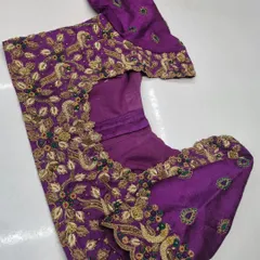 The blouse piece laid flat, showing how the peacock motifs are designed to flow across the sleeves and body of the garment.