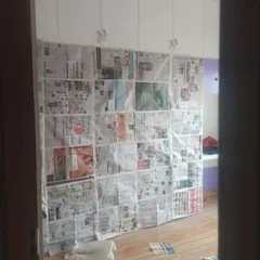 Protecting your built-in furniture is a top priority. This image shows a large wardrobe carefully masked before we start painting the surrounding walls.