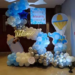 A festive decoration for a Chhathi ceremony. This setup includes a "Welcome" neon sign, a personalized poster, and creative balloon arrangements with elephant and hot air balloon cutouts.