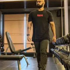 Walking through the dumbbell rack, in the zone. Routine and discipline are the cornerstones of a successful fitness journey.