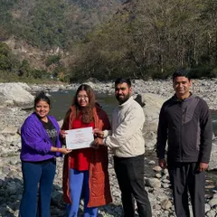 Celebrating the completion of a transformative journey. We honor each participant's commitment with a certificate of completion, presented here against the beautiful, rugged landscape of our Rishikesh retreat location.