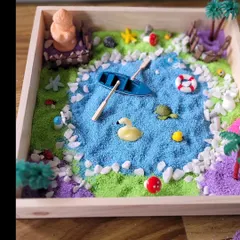 This miniature garden features a peaceful blue pond with a boat and a duck. The process of arranging these small elements is a wonderful exercise in patience and deliberate action for kids.