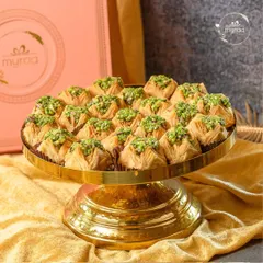 A feast for the eyes and a delight for the palate. This platter of handcrafted baklava, generously topped with pistachios, is a perfect sweet treat for your Eid celebrations.