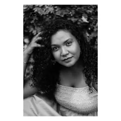 A beautiful and intimate black and white portrait. The focus is entirely on her expression and the soft texture of her curly hair.