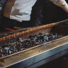 A close-up of our Adana kebab being cooked over hot coals. This traditional method ensures a smoky flavor and perfectly cooked meat, just as you would find in Turkey.