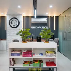 A closer look at the central design elements. The white brick texture wall adds a touch of industrial chic, contrasting with the sleek, dark feature wall. The low-profile bookshelf serves as both storage and a subtle space divider, topped with plants to bring life into the office.