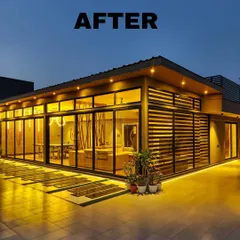 A stunning view of a completed glass house at dusk. The warm interior lighting glows through the large glass panels, showcasing a luxurious living and gaming area inside.