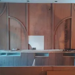 The reception back wall during the fabrication stage. Here you can see the raw plywood and framework being assembled on-site before the final finishes are applied, showing the craftsmanship behind the design.