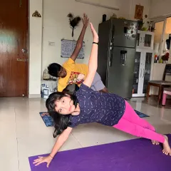 Two young clients practice side plank, one of them smiling at the camera. My classes make fitness fun, building strength and confidence in children.