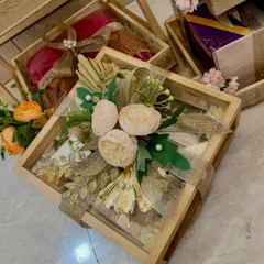 This glass-lidded wooden box is perfect for showcasing delicate items in a wedding trousseau, beautifully decorated with peonies and burlap ribbon.