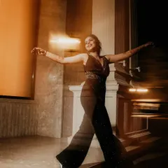 A candid shot of the bride, full of life and movement. The motion blur and warm lighting capture her joyful spirit as she dances during the cocktail party.