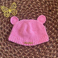 The finished handmade crochet baby beanie. This adorable pink hat with bear ears is soft and gentle, perfect for a newborn.