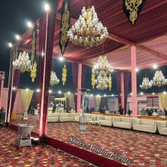 An expansive view of the event space, showcasing the grand scale of our tenting, multiple chandeliers, and spacious seating arrangements.