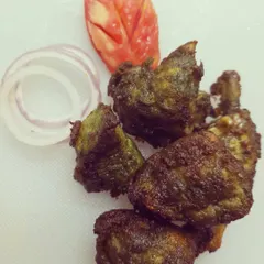 This is the Torpedo Chilli Kebab, a crowd favourite. It's a spicy fried chicken starter, tossed in a bold green chilli dressing that gives it a unique greenish-brown colour. A squeeze of lemon on top makes it perfect.