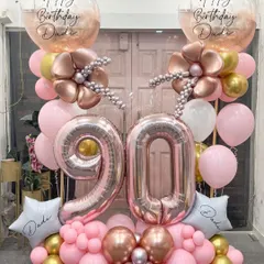 Honoring 90 incredible years with this elegant rose gold and pink arrangement. The large '90' foil balloons are complemented by delicate balloon flowers and personalized star balloons, creating a beautiful tribute for a cherished family member.