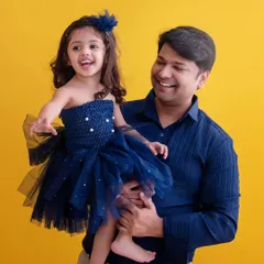 A father's joy is contagious. This candid shot captures a beautiful, happy moment between a dad and his daughter against a vibrant yellow background, full of laughter and life.