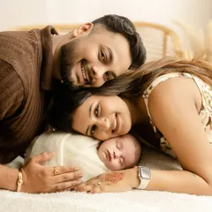 A creative and sweet pose where parents and their newborn stack their heads together. This overhead shot is a unique way to capture the whole family in one frame.
