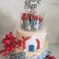This Greek-inspired cake was made for a teenager's dance party. It features blue tile patterns, a little white building, and a lit-up tier for a party feel.