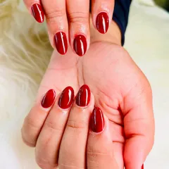 A perfect, classic red manicure. These almond-shaped nails are coated in a rich, vibrant red gel polish with a high-gloss finish.