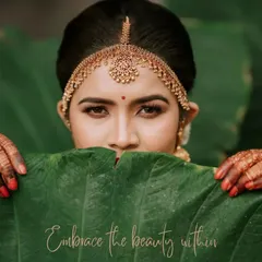 Embrace the beauty within. A creative portrait of a South Indian bride, using a large leaf to frame her face and draw attention to her expressive eyes and intricate matha patti.