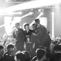 A black and white shot of friends celebrating in the crowd, capturing a timeless moment of camaraderie.