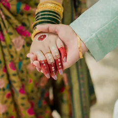 A close-up of the couple holding hands during their '2states' engagement. This image focuses on the bride's hand, adorned with traditional Bengali Aalta, a beautiful and culturally significant detail.