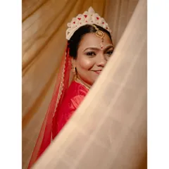 The beautiful Bengali bride, Susheta, with her traditional 'mukut', peeking out from behind a curtain.