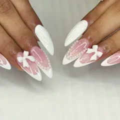 For the bride who wants a dramatic and romantic look, these long stiletto nails are perfect. They feature a combination of classic white and a sheer base with delicate pearl hearts and 3D bows.