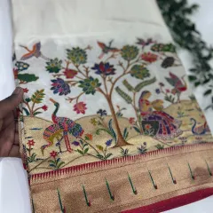 The same exquisite Dola Paithani design on a classic off-white base, allowing the colorful woven motifs to truly stand out.