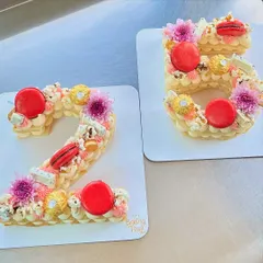 A beautiful set of number cakes for a 25th birthday. These are decorated with my signature vanilla buttercream, fresh flowers, macarons, Ferrero Rocher, and popcorn.