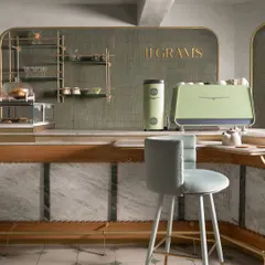 The coffee counter at 11 Grams Cafe is the heart of the space. We used pale green marble, a custom mint-colored coffee machine, and brass-accented shelving to create a functional and aesthetically pleasing focal point that reinforces the brand's identity.