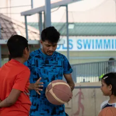 Communication is a big part of our coaching philosophy. In this photo, a coach takes a moment to explain a concept to two young players, ensuring they understand the 'why' behind the drills.
