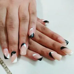 This geometric black and white French tip design offers a sharp, modern, and graphic look on medium-length square nails.