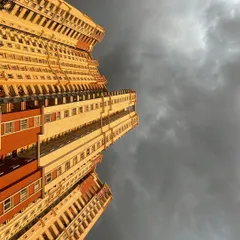 Looking up at a towering high rise against a dramatic sky. I help clients navigate the market for premium apartments that offer incredible views and a prime city location.