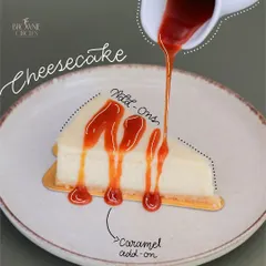 Our classic New York Cheesecake is a blank canvas for your cravings. Here it is being drizzled with a rich caramel sauce, one of our delicious add-on options.