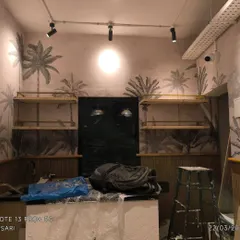 Another view of the cafe, showing the wallpaper and paneling behind the counter area. The design is consistent throughout the space for a cohesive look.