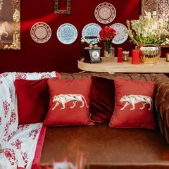 Custom-embroidered tiger motif cushions on a classic leather Chesterfield sofa. This detail from the 'Laal Ishq' wedding added a touch of regal wildlife imagery, tying into the Rajasthani theme.